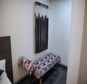 A room with a bed, a bench, and a wall-mounted radiator. - Lakshmi Residency and Mini Hall (Mayiladuthurai)