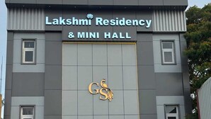 Un edificio con un letrero que dice 'Lakshmi Residency & Mini Hall' y un logotipo con un pavo real.