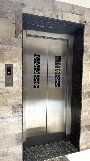 An elevator with a digital display and a control panel.