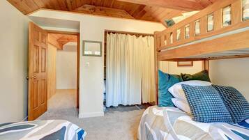 Quarto com beliche, porta que dá para outro cômodo e cortina.