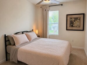 A bedroom with a bed, a nightstand, a window with curtains, and a framed picture on the wall. - Kingsport Time Capsule - 3 bedrooms near  Eastman and Holston Valley hospital (Kingsport)