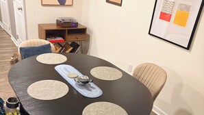 A dining area with a round table, chairs, placemats, and wall art. - Kingsport Time Capsule - 3 bedrooms near  Eastman and Holston Valley hospital (Kingsport)