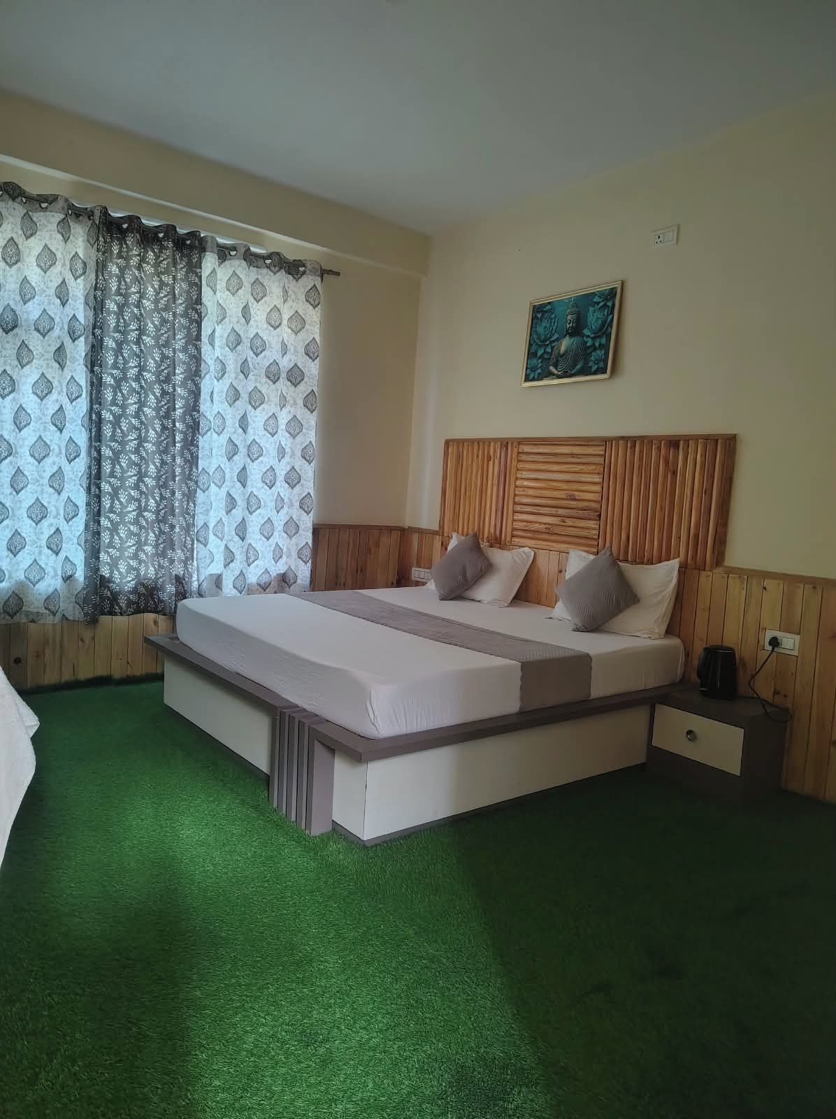 Una stanza con un letto, un comodino e un quadro appeso al muro.