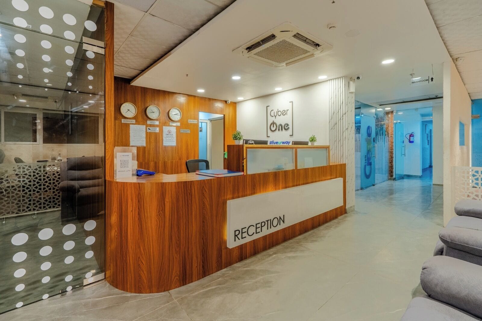 Un mostrador de recepción con detalles de madera, un reloj y un letrero que dice 'Cyber One'.