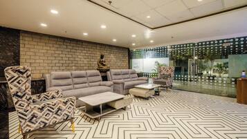 Una sala de estar moderna con sofá, sillones y una mesa de centro.