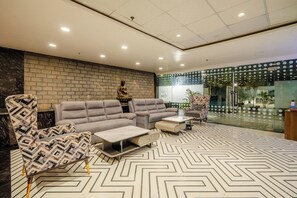 Una sala de estar moderna con sofá, sillones y una mesa de centro.
