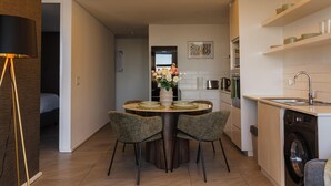 Ett modernt kök med matplats, tvättmaskin och en taklampa.