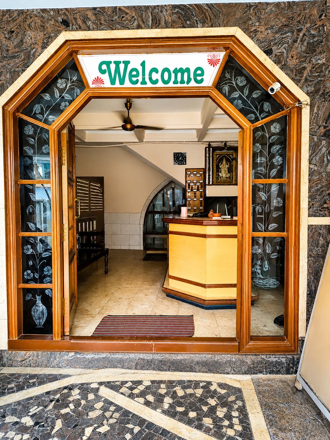 A reception area with a 'Welcome' sign, a reception desk, a clock, and a decorative wall.