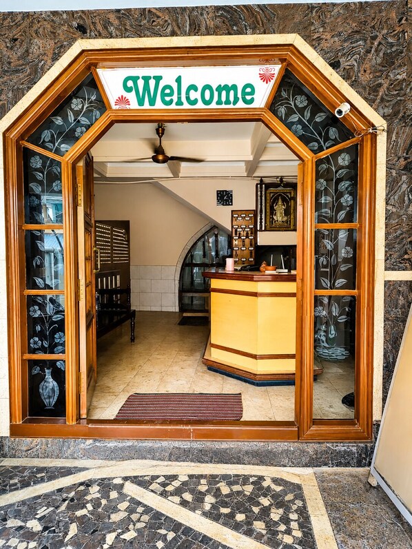 A reception area with a 'Welcome' sign, a reception desk, a clock, and a decorative wall.