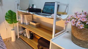 A neatly organized workspace with a laptop, books, and decorative items on shelves.