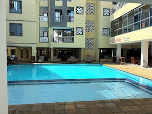 Un hotel con piscina, area salotto esterna e ristorante chiamato 'The HOME Plate'.