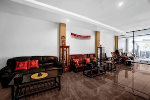 A modern lobby with a leather sofa, wooden chairs, and a coffee table. A banner on the wall reads 'DPR Republic of Indonesia.' - Hotel O Near Ciputra World Surabaya Formerly Darmo Residence (Surabaya)