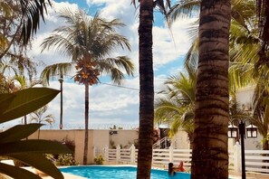 A swimming pool surrounded by palm trees and a white fence. - Blue Water Retreat – Cozy 1-Bedroom Stay Near Flic en Flac Beach (Flic en Flac)