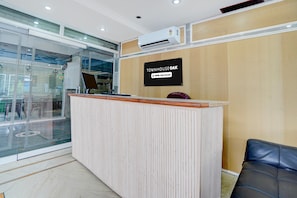 Una mesa de recepción con un cartel que dice 'TOWNHOUSE OAK' y 'oyo-Serviced'.