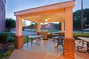 A covered patio area with a grill, tables, and chairs. - Family Vacation Retreat! 2 Modern Suites | Onsite Parking | 1.2 Mi to Six Flags (Arlington)