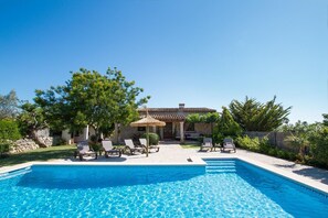 A swimming pool with lounge chairs and a stone building in the background. - Stone Majorcan Villa With Gardens (Pollença)