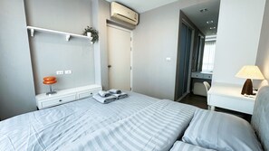 Ein Hotelzimmer mit Bett, Nachttisch, Lampe und Schrank.