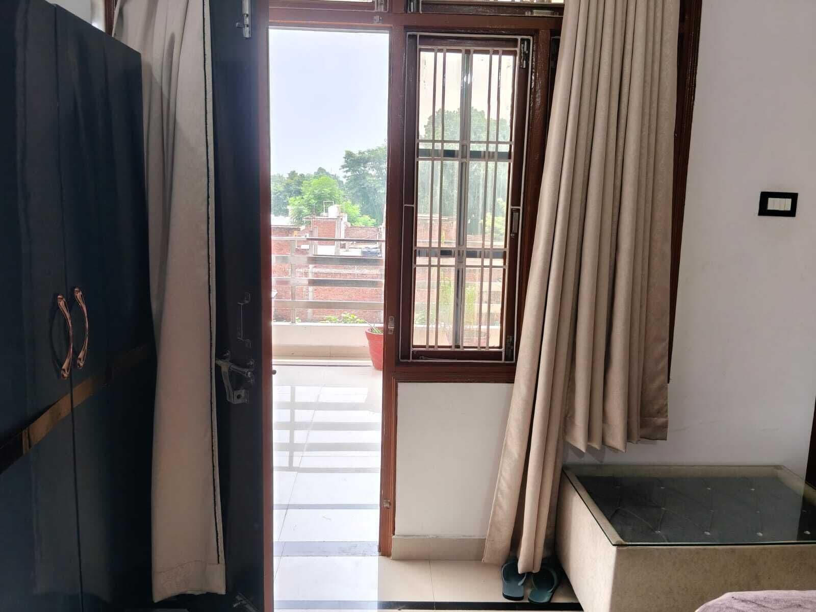 Et værelse med en skydedør til en balkon, en seng med glasgavl og et garderobeskab.