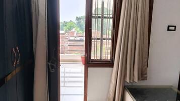 Et værelse med en skydedør til en balkon, en seng med glasgavl og et garderobeskab.