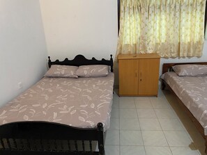 Un dormitorio con dos camas, un armario de madera y un ventanal con cortinas.