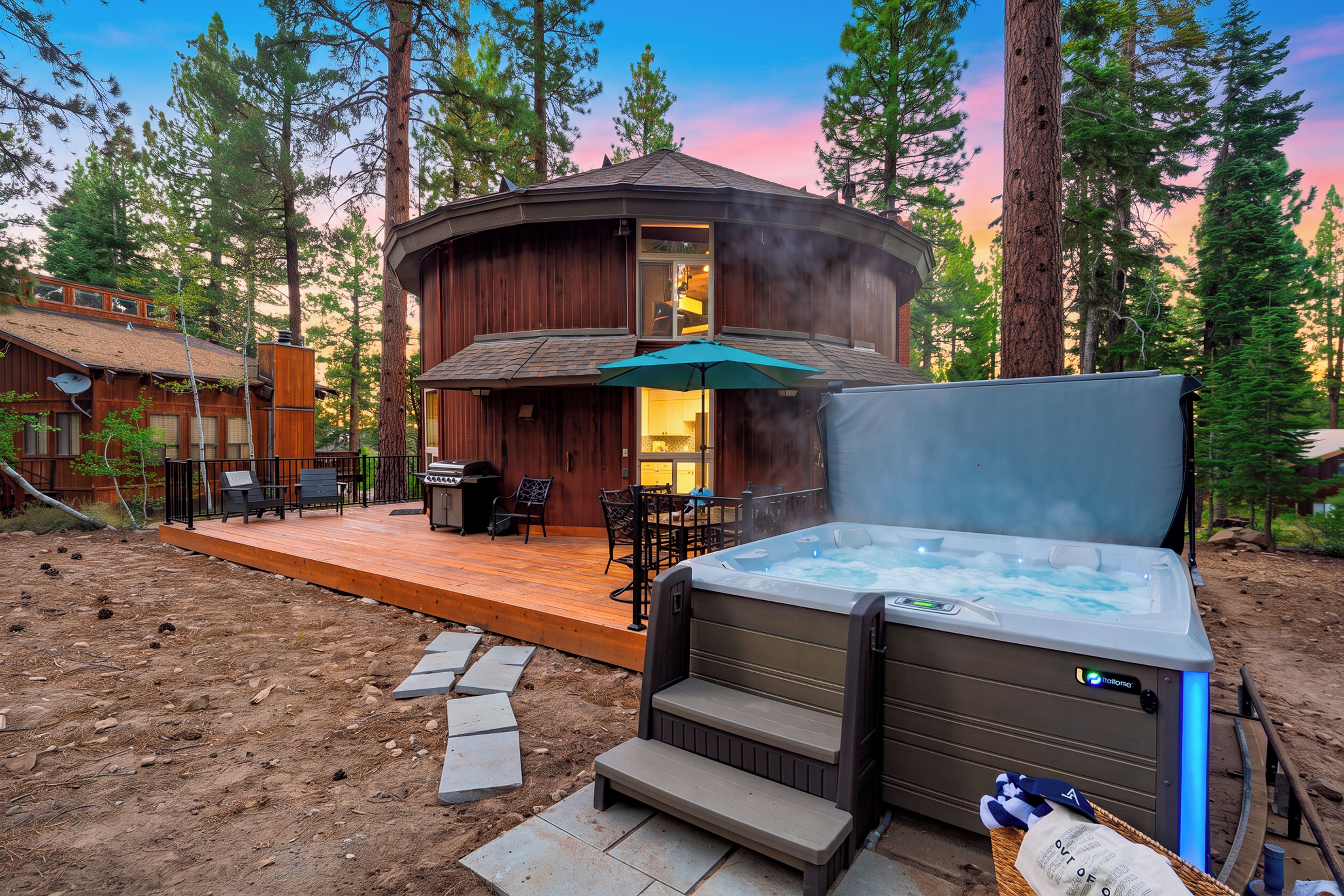 Eine Holzhütte mit Whirlpool, Sitzgelegenheit im Freien und einer Terrasse.