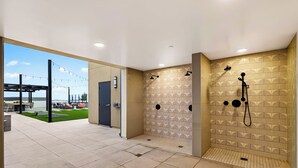A modern bathroom with patterned tiles, a shower, and a view of an outdoor area with seating. - 2 Condos + Rooftop Pool + Gym + Sauna | Desert Ridge | Azur by AvantStay (Phoenix)