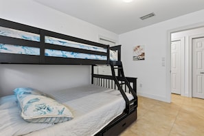 Ein Stockbett mit einer weißen Matratze und einem Kissen mit blauem Blumenmuster.