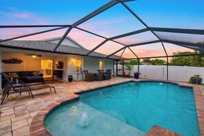 A swimming pool with a patio area, a covered seating area, and a view of the sky. - Naples Park Stay • Private Pool + Lanai • Near Vanderbilt Beach | Lanai & Light (Naples)