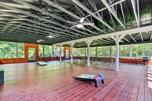 Un pavillon intérieur doté d’un plancher en bois, de ventilateurs de plafond et de tables de pique-nique.