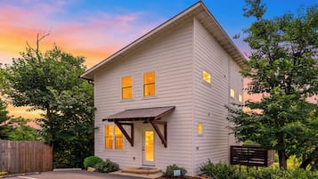 A two-story house with a front porch, a garage, and a driveway.