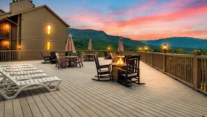 Eine Terrasse mit Sitzgelegenheiten im Freien, einem Feuerkorb und Blick auf die Berge.