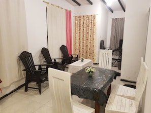 Un comedor con una mesa, sillas y cortinas.