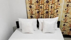 A bed with white bedding and a black frame, accompanied by two pillows. - Shalom View Homestay  (Kandy)