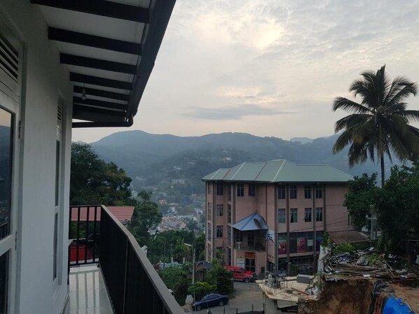 Un edificio con balcón que da a un paisaje montañoso.