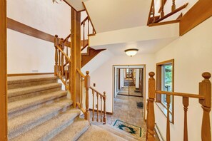 A staircase with wooden railings and carpeted steps leading to a second floor. - Alpine Chalet + Decks + Game Room | Near Ski + Lake | Stillwood (Stateline)