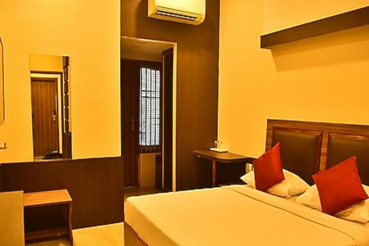 Une chambre d’hôtel équipée d’un lit, d’un bureau, d’une chaise et d’un appareil de climatisation.