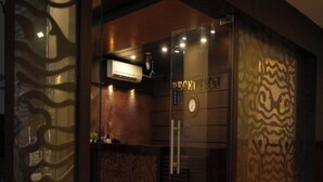 Una zona de recepción con mostrador, un reloj y un papel tapiz decorativo.