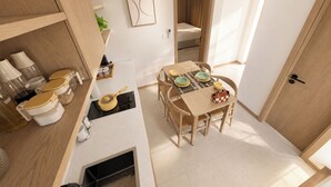 Una cocina compacta con comedor, estufa integrada y un refrigerador pequeño.