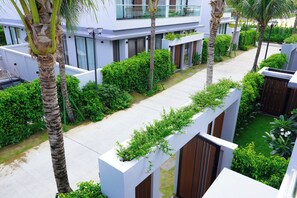 A modern residential building with a covered walkway, lush greenery, and a clear sky. - Sonasea Villas Collection Lagom  (Phu Quoc)