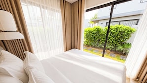Habitación de hotel con cama, cortinas y vistas al exterior.