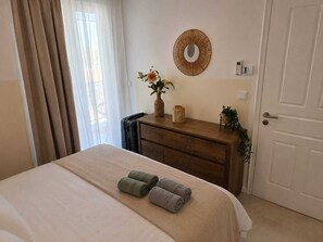 A hotel room with a bed, a dresser, a mirror, and a door. - Villa Irini Ocean View 2-bedroom apartment with AC in charming Fryni (Fryni)