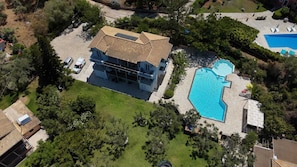A two-story house with a swimming pool, surrounded by greenery and a paved driveway. - Villa Irini Ocean View 2-bedroom apartment with AC in charming Fryni (Fryni)