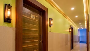 Ein Hotelgang mit einer Holztür mit der Aufschrift '304', einer Wandleuchte und einem gefliesten Boden.