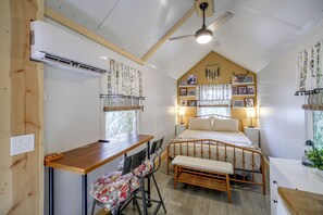 Ein gemütliches Schlafzimmer mit Bett, Nachttischen, Schreibtisch und Stuhl.