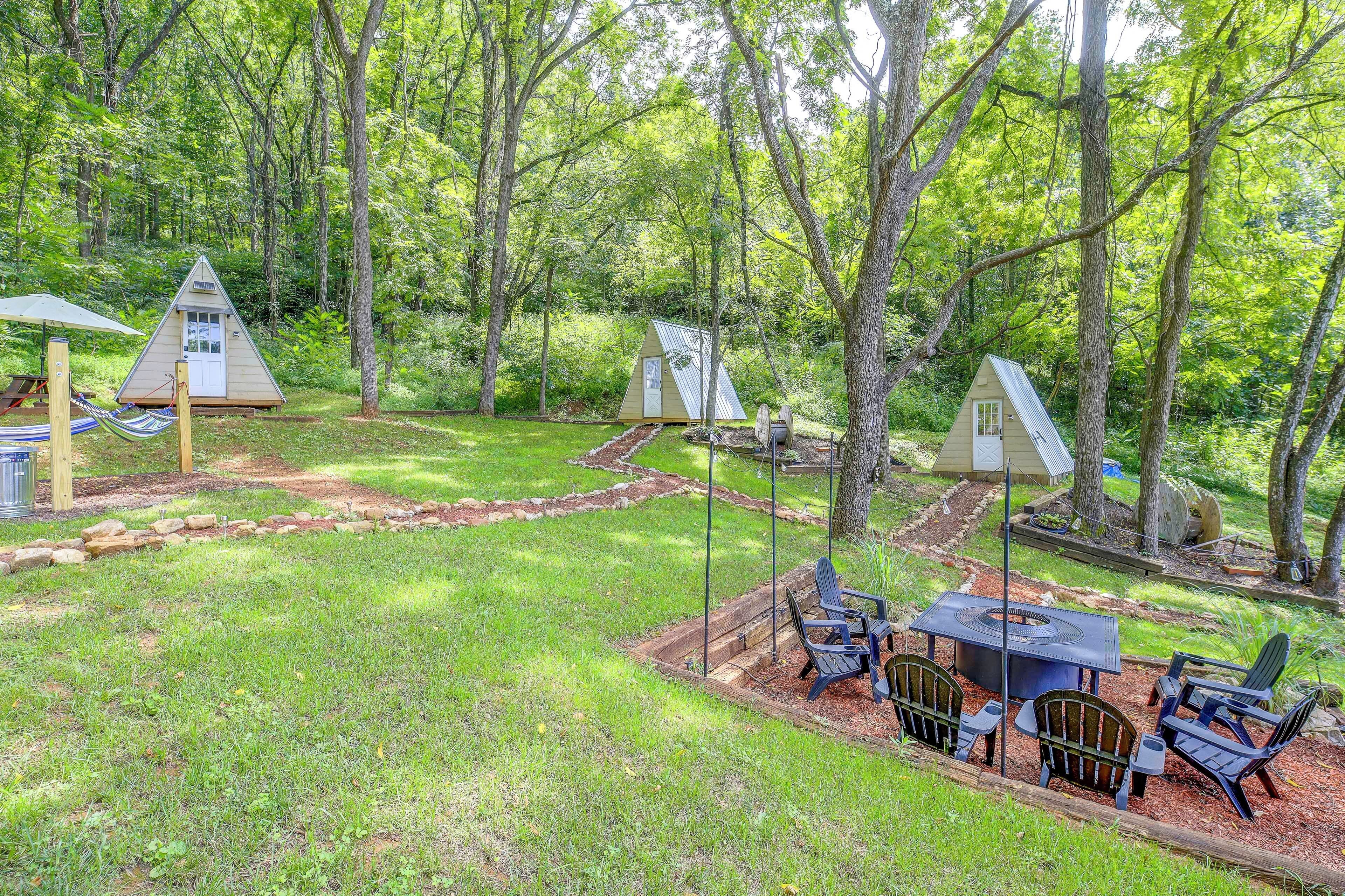 A campsite with multiple treehouses, a picnic table, and outdoor seating.