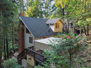 A two-story house with a wooden deck and a staircase. - Forest Views + Firepit Gazebo + Deck Dining | Near Village | Wilderness Lodge (Lake Arrowhead)
