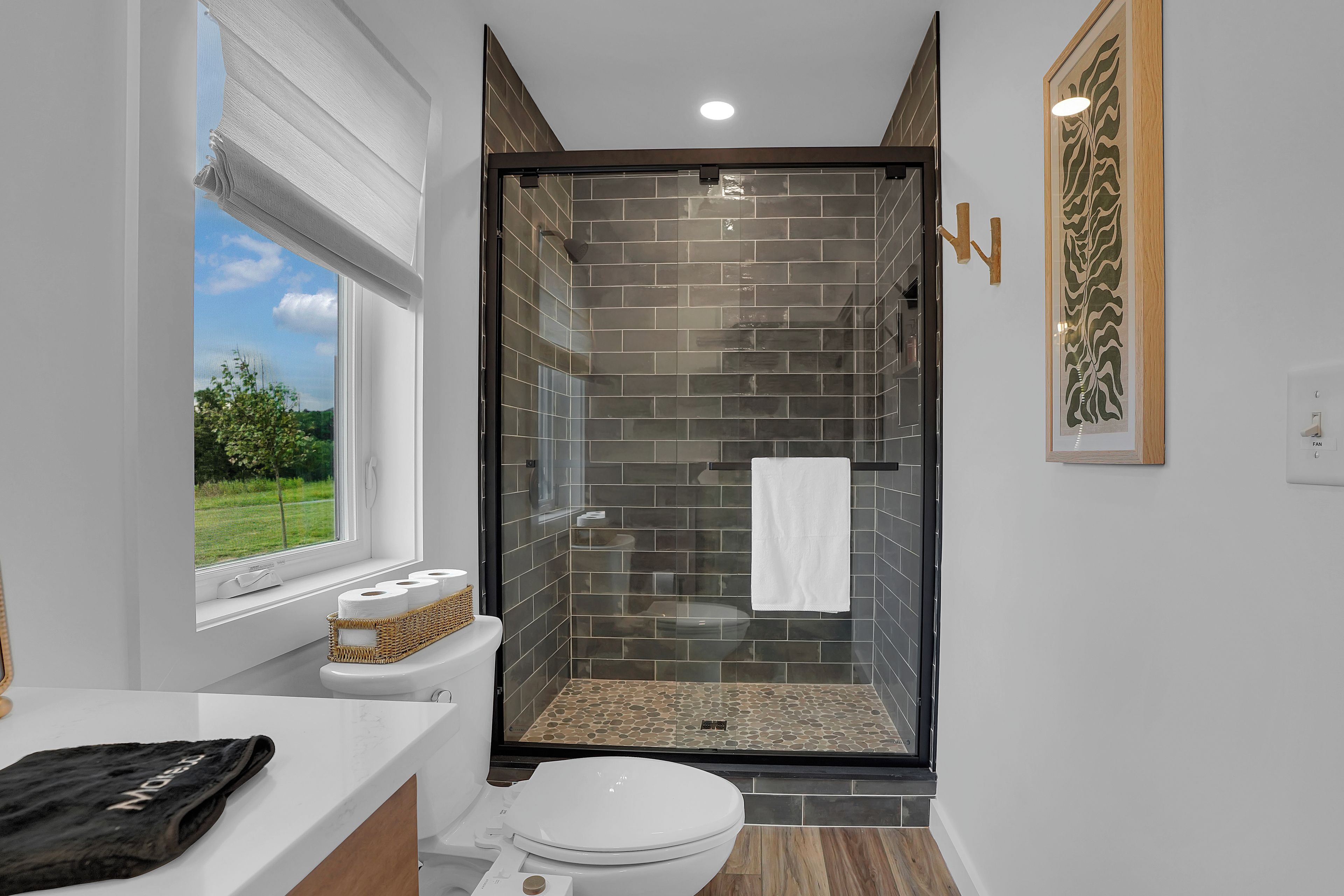 Un baño moderno con ducha de vidrio, inodoro y lavamanos.