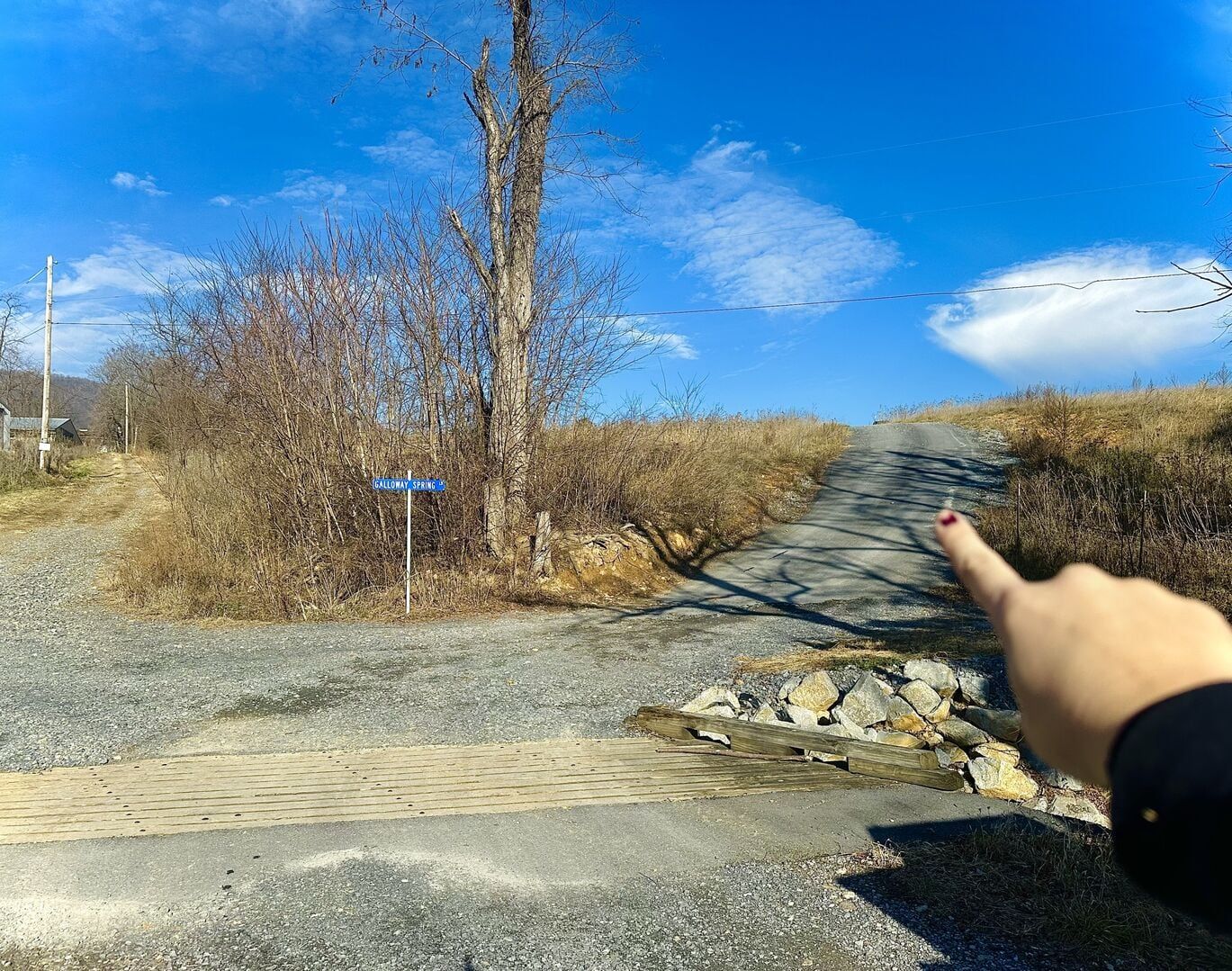 A rural road with a blue sign indicating 'Galloway Spring'.