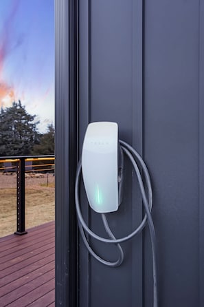 A charging station attached to a wall with a cable connected to it.