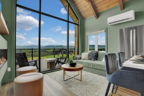 Un amplio salón con un gran ventanal que ofrece vistas al campo.